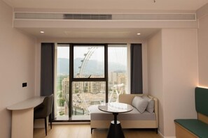 A modern room with a sofa, a small table, and a desk. - Lihao Hotel (Chongqing Yongchuan High-speed Railway Station) (Chongqing)