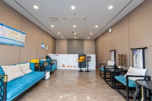 A hotel lobby with a reception desk, seating area, and a blue sofa. - Lihao Hotel (Chongqing Yongchuan High-speed Railway Station) (Chongqing)