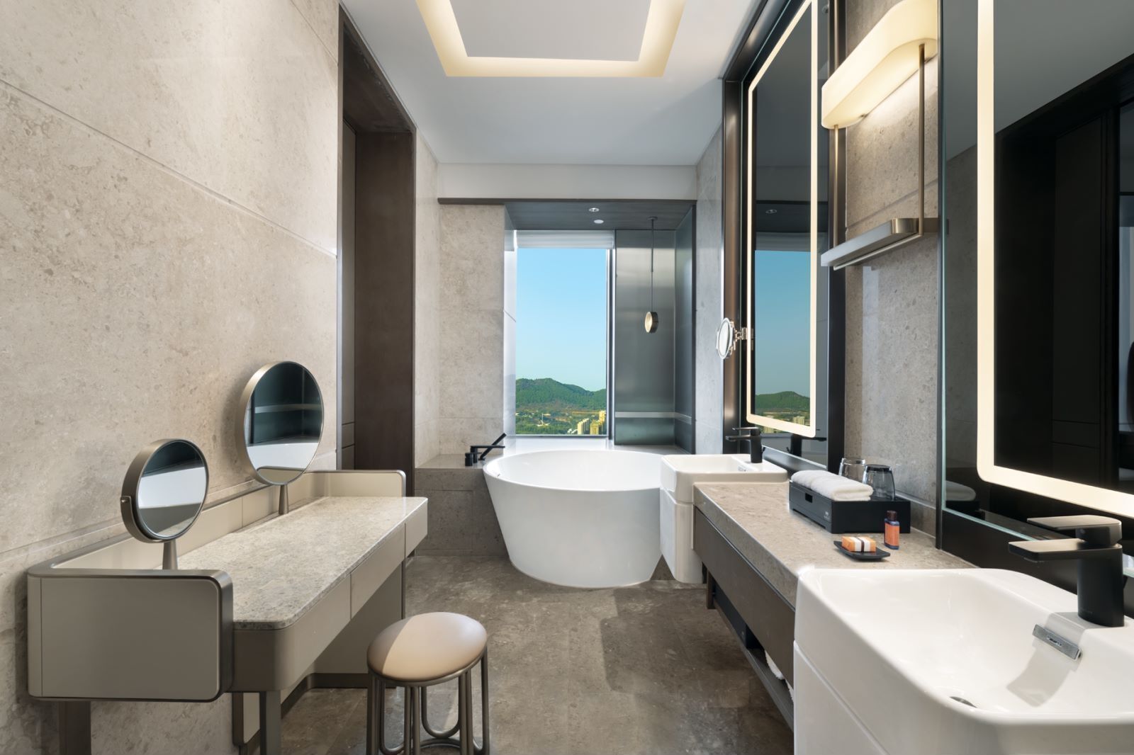 Ein modernes Badezimmer mit zwei Waschbecken, einer großen Badewanne und einem Spiegel.