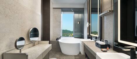 Ein modernes Badezimmer mit zwei Waschbecken, einer großen Badewanne und einem Spiegel.