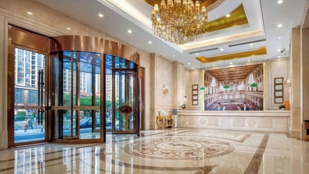 A luxurious lobby with a grand chandelier, a large round marble floor, and a view of the city through the glass doors. - Vienna Hotel (Liuyang Xincheng International) (Liuyang)