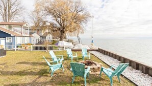 A waterfront property with outdoor seating and a fire pit. - 80 Feet of Private Lakefront House (Amherstburg)