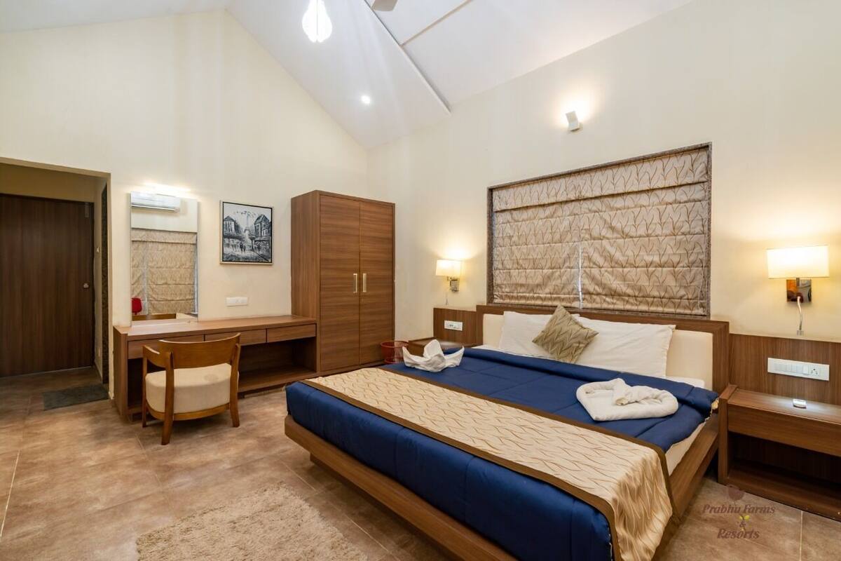 Ein Schlafzimmer mit Bett, Nachttischen, Schreibtisch, Kleiderschrank und Kopfteil.