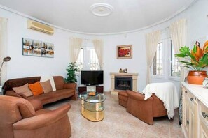 A living room with a sofa set, a TV, a fireplace, and a potted plant. - CH Villa Plara La Marquesa Golf (Ciudad Quesada) (Ciudad Quesada)