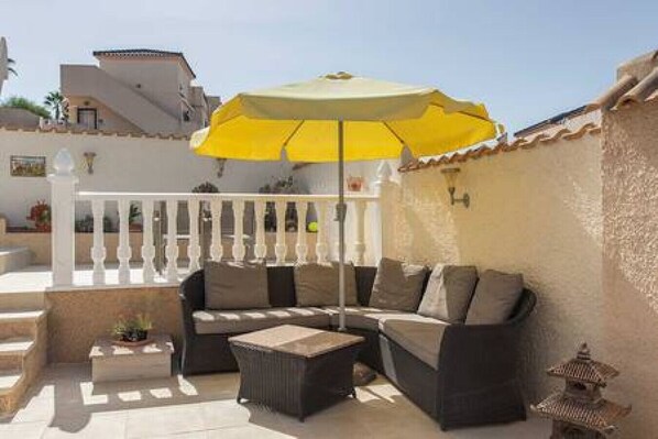 A patio with a sofa, a small table, and a yellow umbrella. - CH Villa Plara La Marquesa Golf (Ciudad Quesada) (Ciudad Quesada)