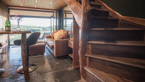 A wooden staircase leading to a loft area with a view of the countryside. - Tawny Lodge - 1 Bedroom - Blossom Farm (Haverfordwest)
