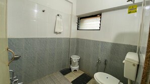 Une petite salle de bain comprenant des toilettes, un lavabo et un espace douche.