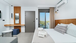 Une chambre d’hôtel moderne équipée d’un lit, d’une table de chevet et d’un petit coin salon.