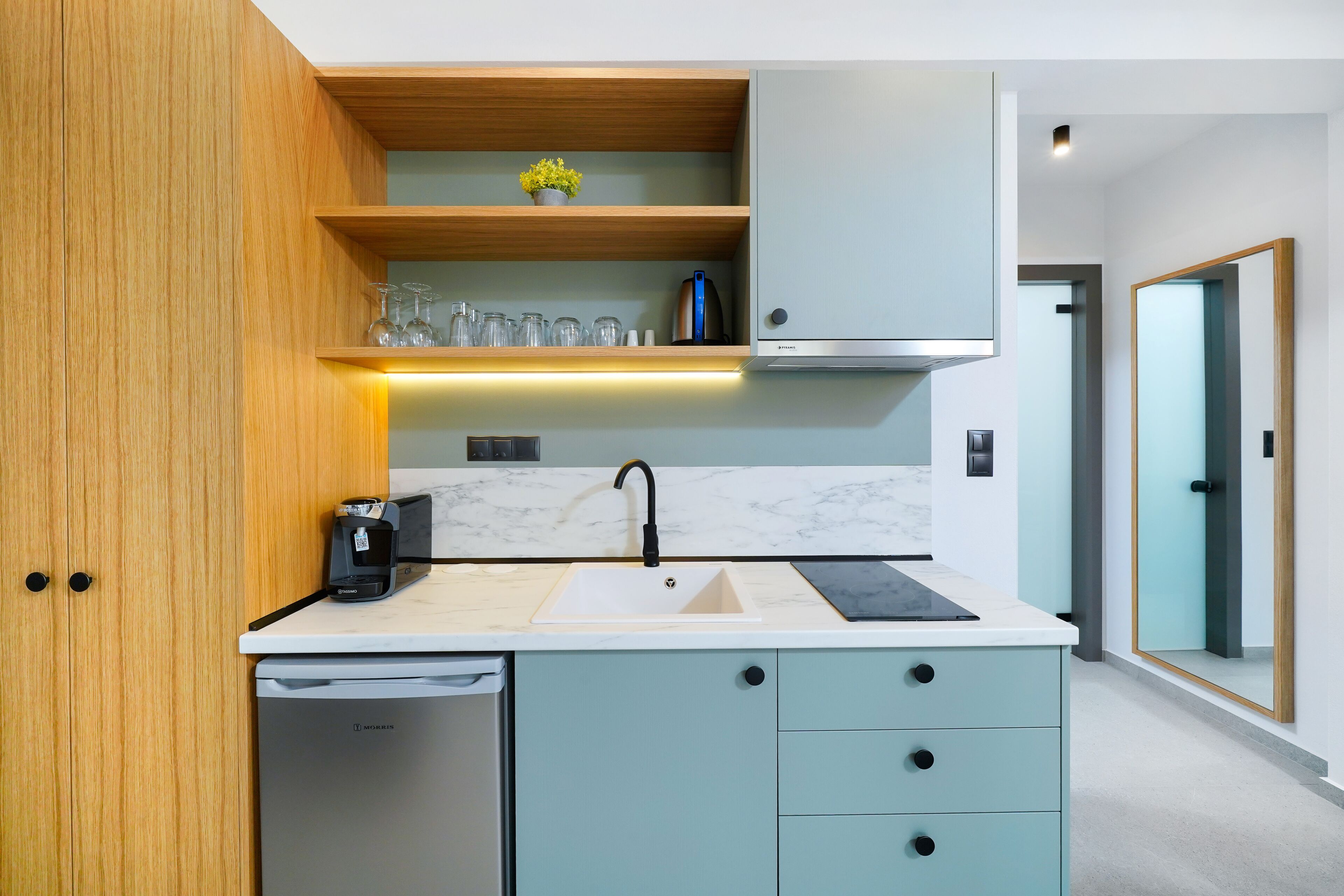 A modern kitchen with a built-in dishwasher, a coffee machine, and a marble countertop.
