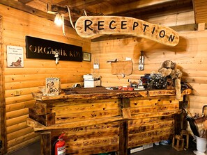 Un comptoir d’accueil surmonté d’une enseigne en bois portant l’inscription « RÉCEPTION ».