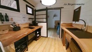 A compact kitchen with wooden countertops, a coffee maker, and a sink. - Chalet à Proximité de L'océan Avec Piscine Insolite (Queyrac)