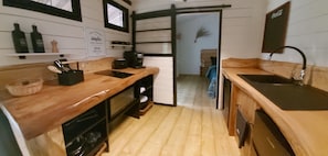 A compact kitchen with wooden countertops, a coffee maker, and a sink.
