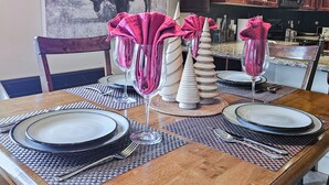 A dining table set with plates, glasses, and cutlery, with a buffalo mural on the wall behind. - Pet-Friendly 2-Bedroom Condo Near Hot Springs (Radium Hot Springs)