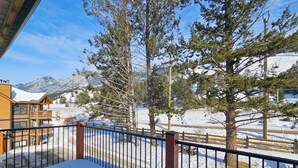 A wooden building with a balcony, surrounded by snow-covered ground and trees. - Pet-Friendly 2-Bedroom Condo Near Hot Springs (Radium Hot Springs)