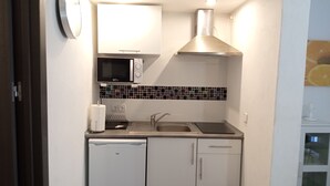 A compact kitchen with a microwave, sink, and a built-in oven. - CAP DE MAR (Alcudia)
