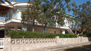 A modern two-story house with a balcony, stone wall, and a small garden area. - CAP DE MAR (Alcudia)