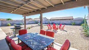 An outdoor patio with a covered seating area, a grill, and a view of a residential neighborhood. - LUXURY Living 2 (Yuma)