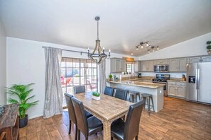 A spacious kitchen with a large island, modern appliances, and a dining area with a wooden table and chairs.