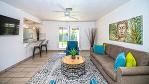 A living room with a sofa, coffee table, and artwork on the wall. - LUXURY Living 4 (Yuma)