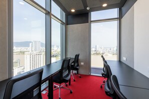 A conference room with a city view, large windows, and a red carpet. - Wink Danang Centre, Unscripted by Hyatt - 24 Hours stay (Da Nang)