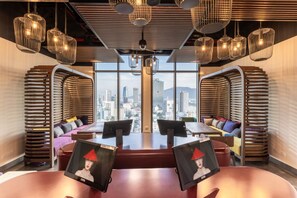 A modern meeting room with a city view, tiered seating, and pendant lighting. - Wink Danang Centre, Unscripted by Hyatt - 24-Hour Stays (Da Nang)