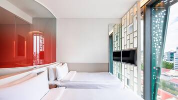 A hotel room with two beds, a large window with a view of the city, and a red decorative panel.
