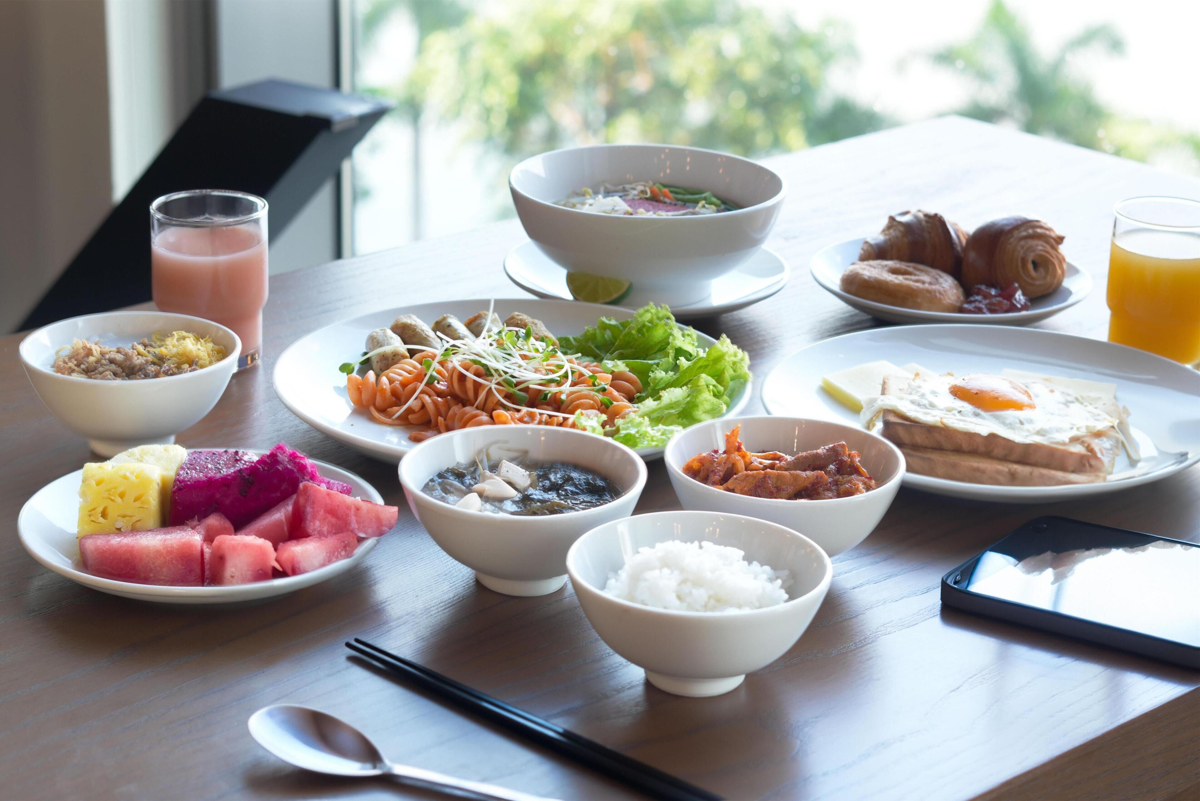 A table with various dishes including rice, soup, and fruits.