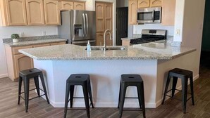 A modern kitchen with granite countertops, stainless steel appliances, and wooden cabinets. - Luxury Living 6 (Yuma)