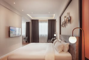 A modern hotel room with a large bed, a flat-screen TV, a desk, and a window with curtains. - FUHOTEL (Perai)