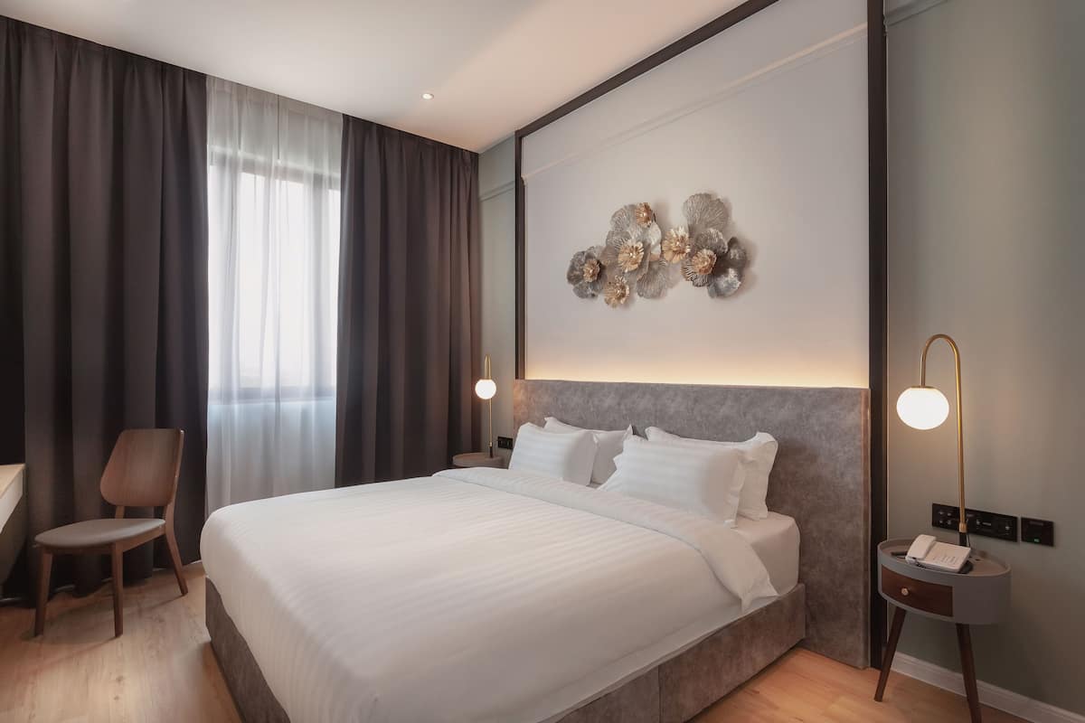 Een moderne hotelkamer met een groot bed, een bureau en een stoel.