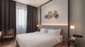 A modern hotel room with a large bed, a desk, and a chair.