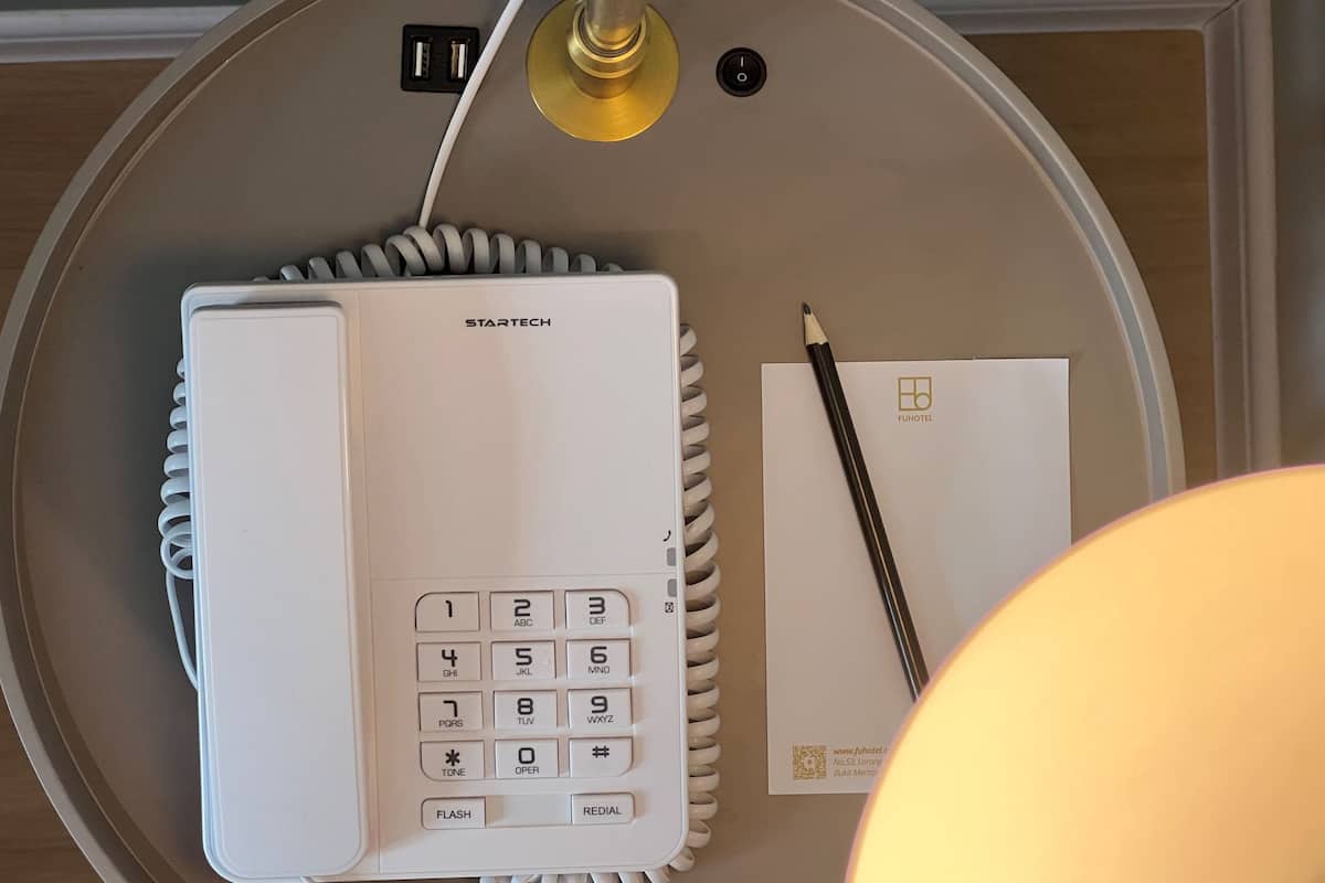 Een Startech telefoon, een FUHOTEL brochure en een pen op een tafel.
