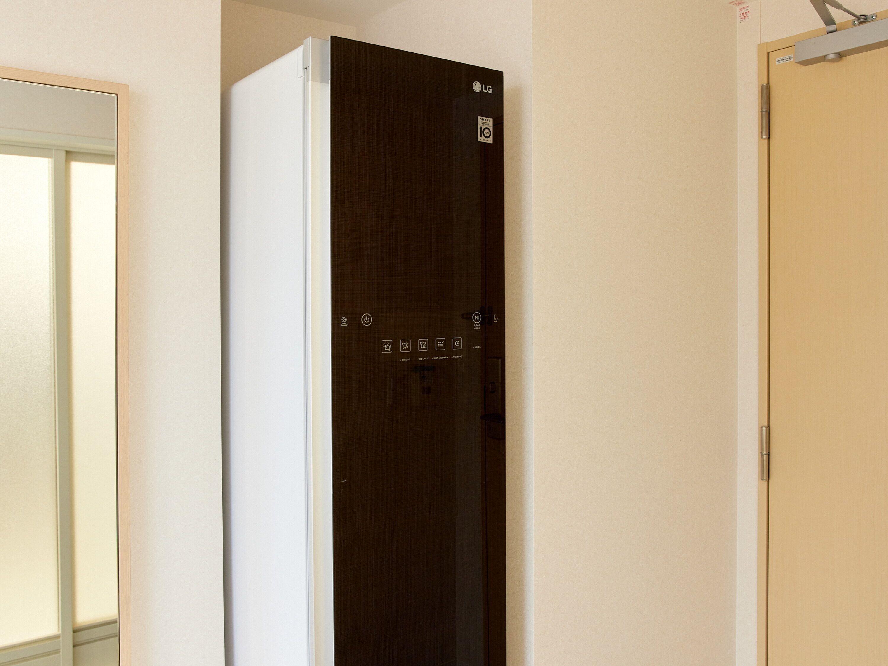 A modern, dark-colored refrigerator with a control panel and a visible brand logo.