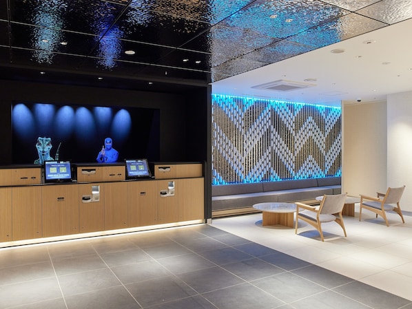A modern reception area with a digital display, wooden cabinets, and a patterned wall. - Henn na Hotel Premier Kagoshima Tenmonkan (Kagoshima)