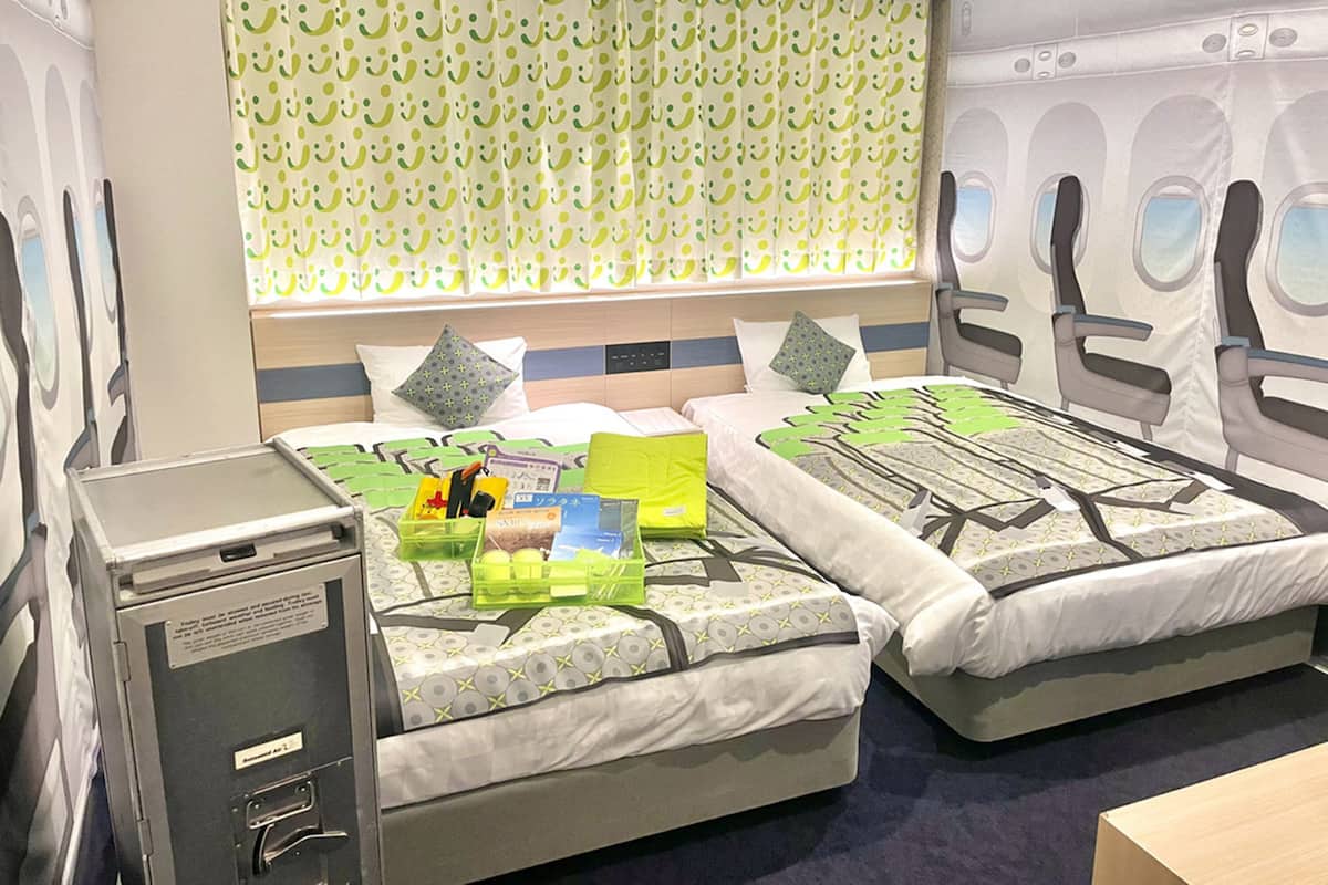 Une chambre d’hôtel avec deux lits, un bureau et un lave-linge.