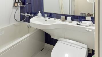 A modern bathroom with a bathtub, two sinks, a toilet, and a mirror.