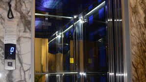 Un ascensor con piso de mármol y pantalla digital.