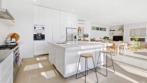 Enjoy cooking in this kitchen with a central island, oven, and stainless steel range, complemented by a dining area with a large window.