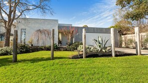 Stylish home with a beautifully landscaped yard featuring a variety of plants and a wooden fence.