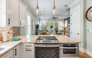 A modern kitchen with a central island, stainless steel appliances, and pendant lighting.
