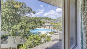 A view of a swimming pool surrounded by trees and buildings.