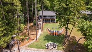 A modern house with a large deck, a fire pit, and kayaks. - Home w/Dock, SUPs, Kayaks, Arcades, Ping-Pong (Leesville)