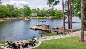 A lakeside deck with outdoor seating and a dock extending into the water. - Home w/Dock, SUPs, Kayaks, Arcades, Ping-Pong (Leesville)