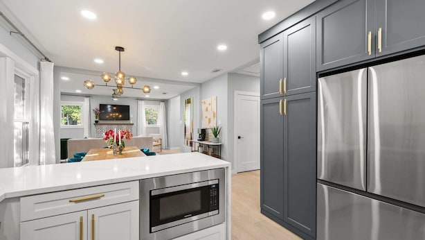 A modern kitchen with a central island, stainless steel appliances, and a grey cabinetry design. - The Hansel-Modern 4 Bed, 3 Bath Bungalow, Hot Tub (Dallas)