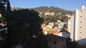 A residential area with a stone house, a swimming pool, and a view of a hill with buildings. - Charmant Studio 42 M2 10 min de la Plage (Le Cannet)