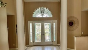 A spacious hallway with a large arched window and a decorative ceiling light. - Family Canal House/ Heated Pool, Kayaks, BBQ, Lift (Cape Coral)