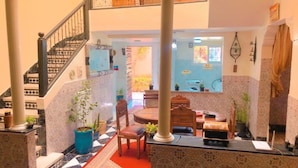 Un vestíbulo amplio con una escalera, una zona de comedor con una mesa redonda y sillas, y vistas al área de la cocina.