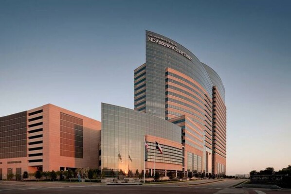 Situated on a spacious campus, the MD Anderson Cancer Center features a unique architectural design with a large glass facade.