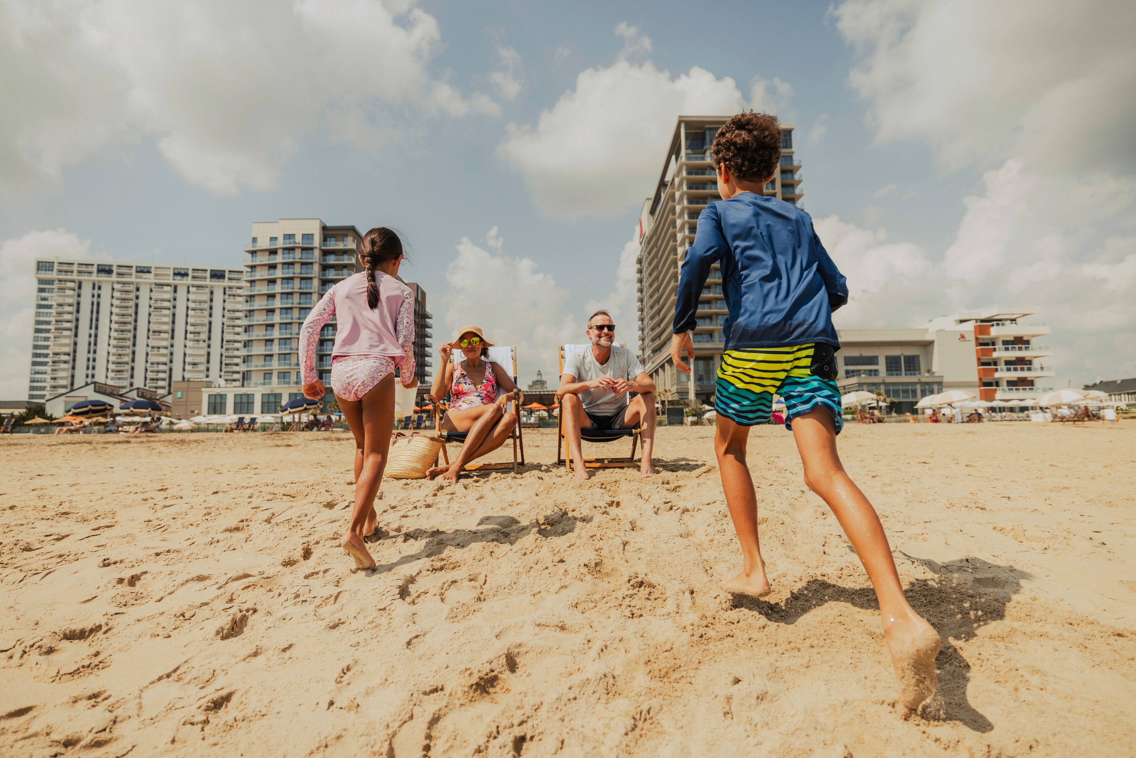 Una spiaggia sabbiosa con persone e edifici sullo sfondo.