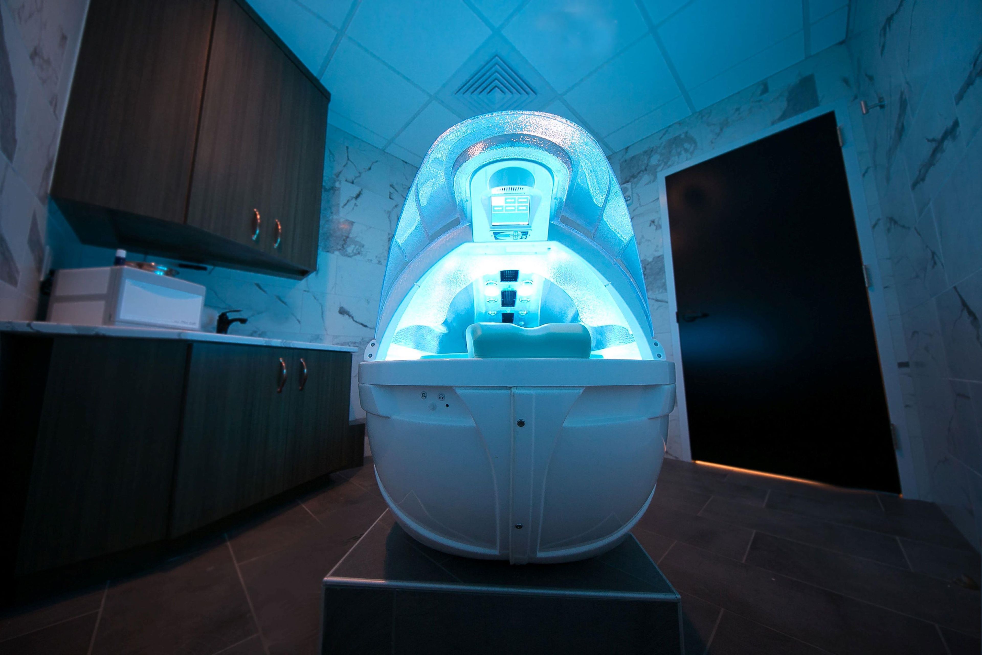 Uma sauna com painel de controle, armários de madeira e piso ladrilhado.
